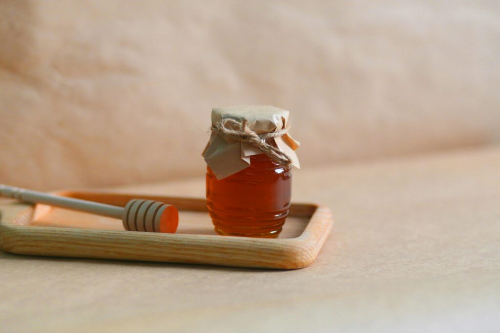 A bottle of Pure Desi Honey on a rustic wooden table, representing its natural, fresh, and authentic qualities.